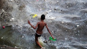 An Indian youth walks into polluted flood waters after the river Ganges rose following heavy monsoon rains in Allahabad on July 10, 2016. / AFP / SANJAY KANOJIA        (Photo credit should read SANJAY KANOJIA/AFP/Getty Images)