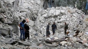 سكان وسط انقاض منزل دمرته طائرات حربية في حلب بسوريا يوم الجمعة. تصوير: عبدالرحمن اسماعيل - رويترز